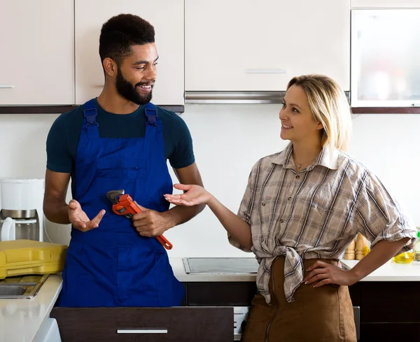 Satisfied girl thanking black professional plumber