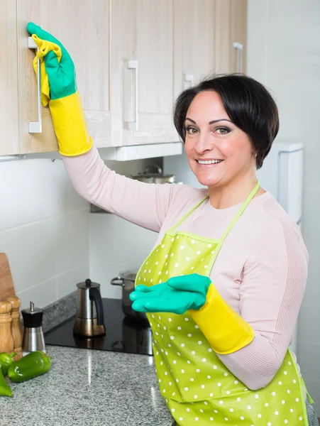 Housewife removing spots from cupboards