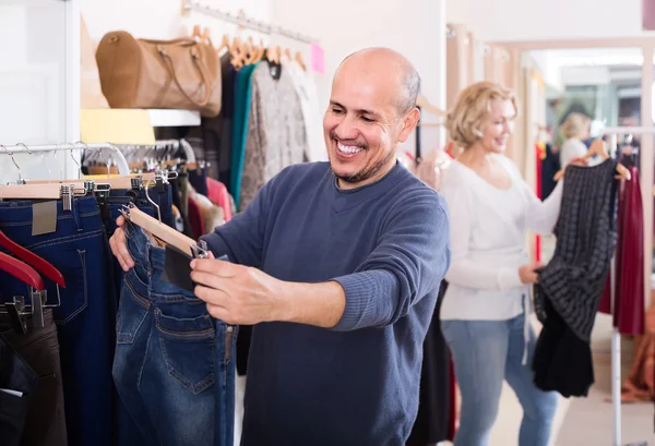 Spouses buying pair of classic jeans in boutique