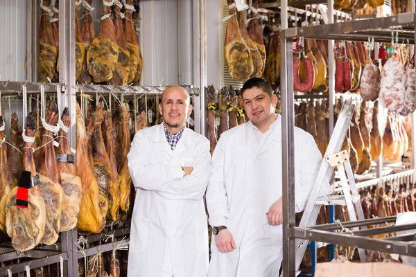 Technologist with butcher checking wurst