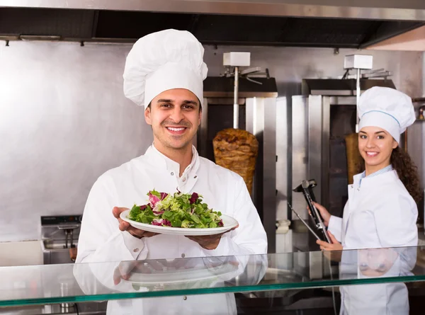 Chefs with kebab and salad at bistro