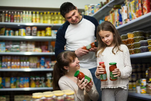 Happy family purchasing canned food