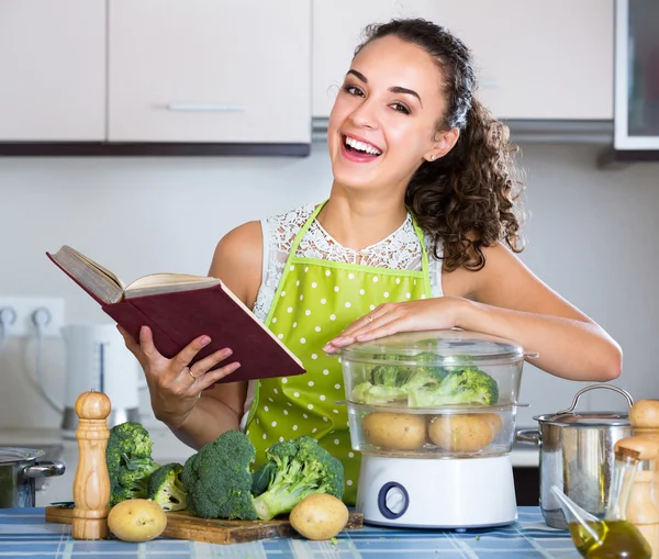Smiling young woman with book  and  vegetables