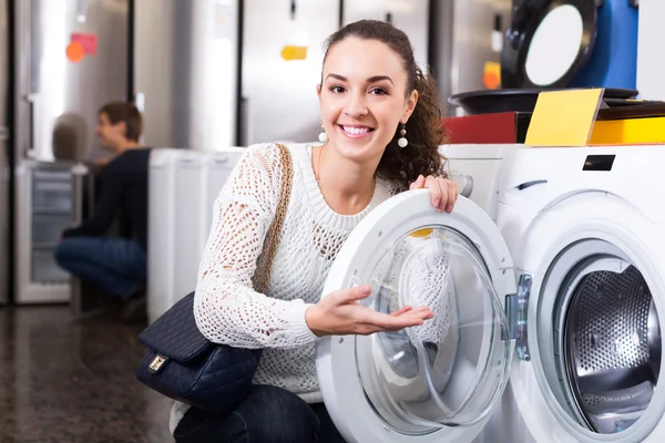 Woman choosing new laundry machine