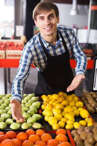 Grocery worker selling seasonal fruits