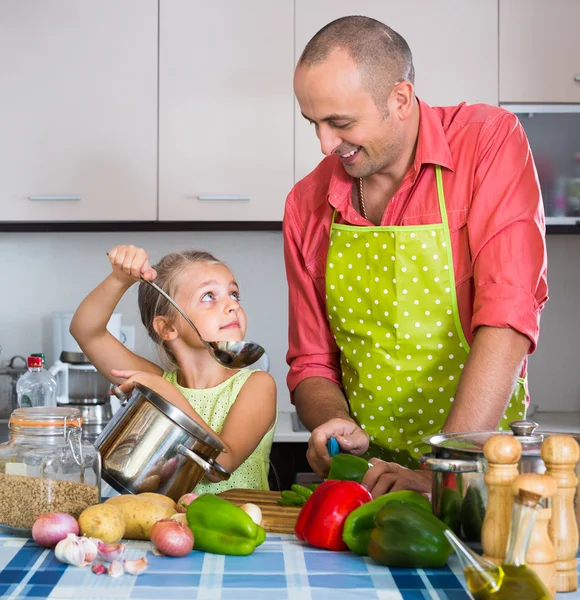 Girl helping father to prepare dinner