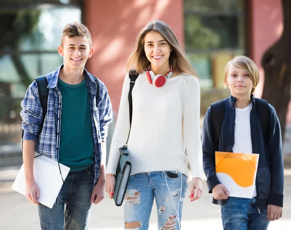 Teens going to school with papers