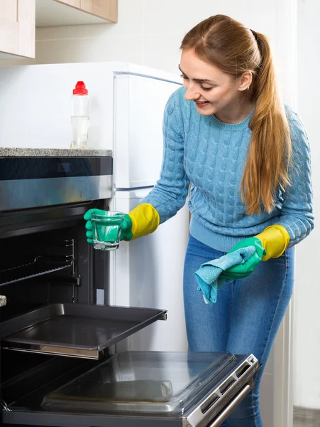 Girl in gloves removing snuff in oven