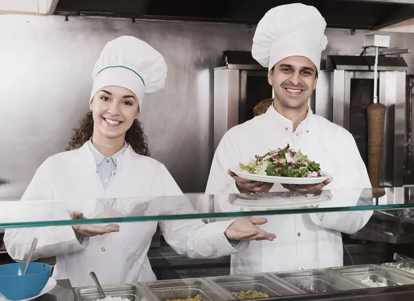 Chefs with kebab and salad