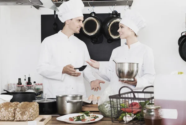 Two chefs cooking food