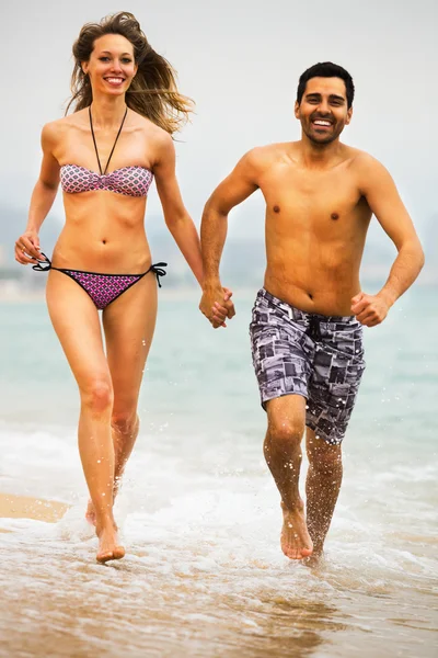 Young couple runs near the sea