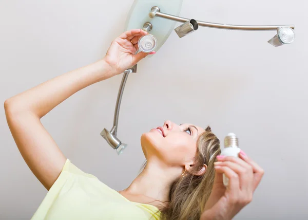 Woman changing light bulbs