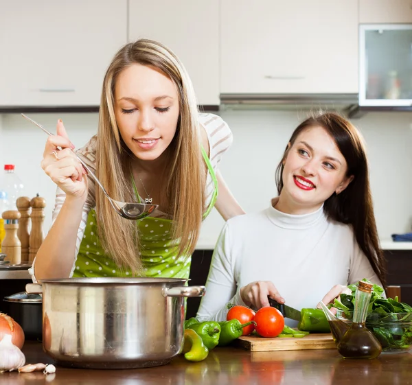 Two girlfriends cooking  with vegetables