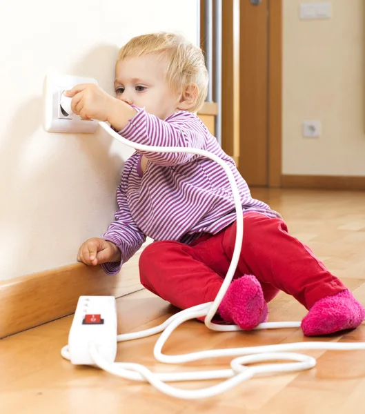 Baby girl playing with electrical extension