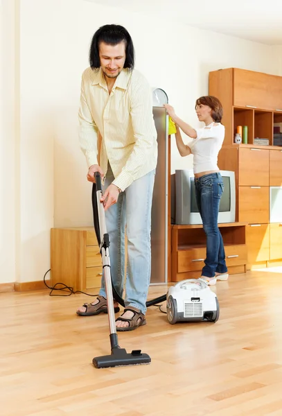 Couple cleaning with vacuum cleaner