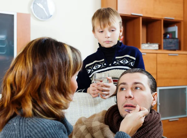 Ailing man surrounded by caring wife and  son