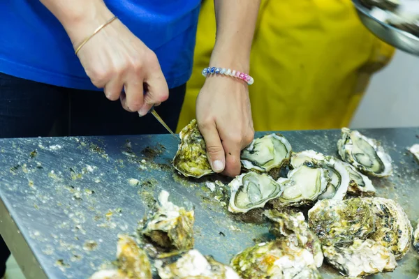 Worker opening oysters
