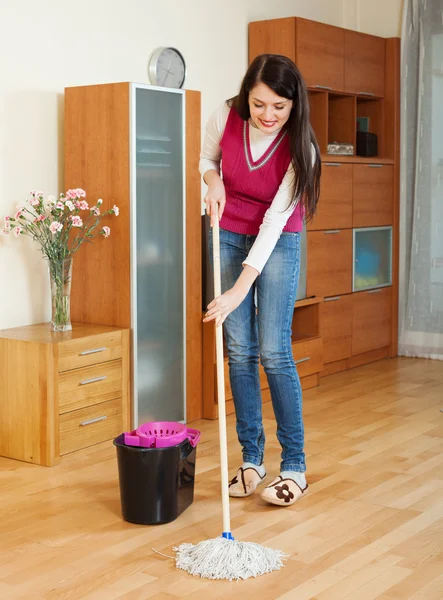 Smiling  woman washing  floor with mop