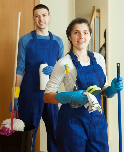 Smiling cleaners team at door