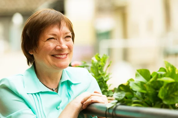 Female pensioner resting at balcony