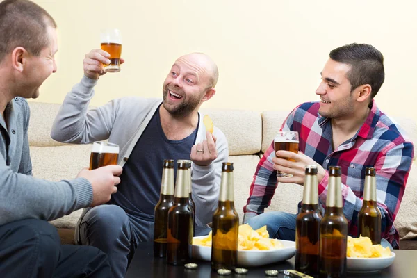 Three happy friends drinking beer