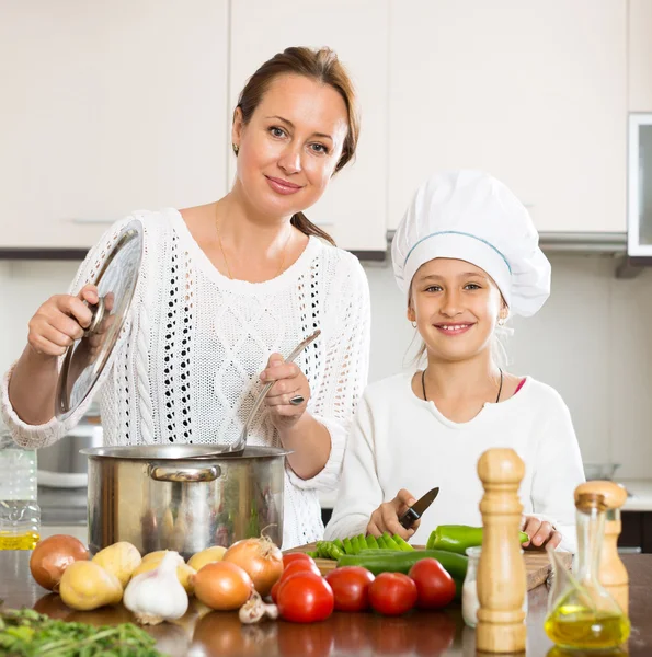Mother and daughter preparing soup
