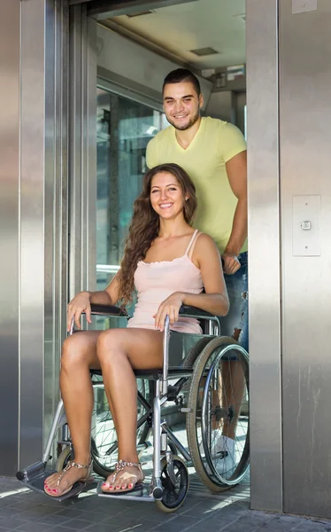 Man helping handicapped girl at elevator