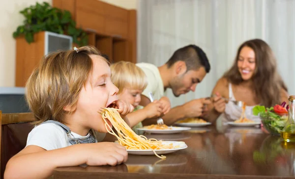 Family of four eating spaghetti