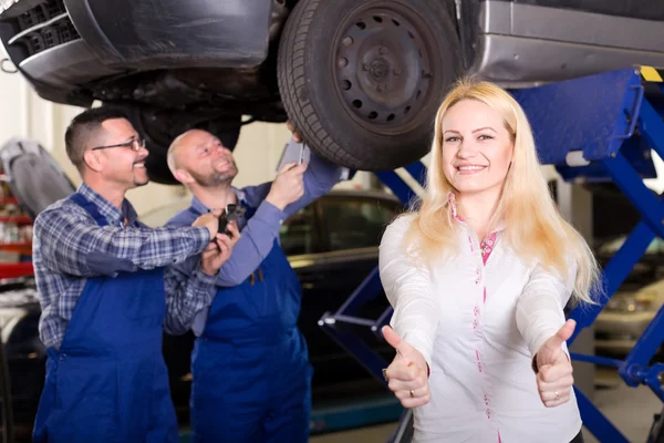 Happy woman at car repair shop