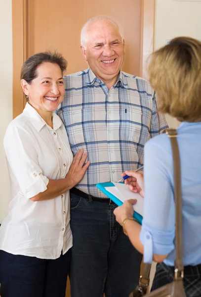 Couple answering questions of employee  in door