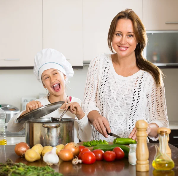 Smiling girl and mom at kitchen