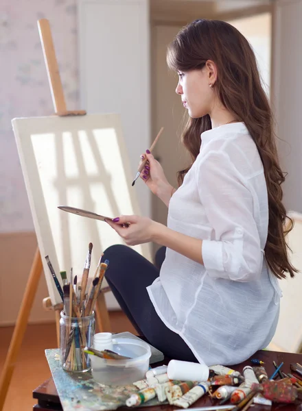 Female artist with oil colors and brushes