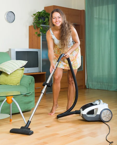 Girl  in skirt cleaning with vacuum cleaner