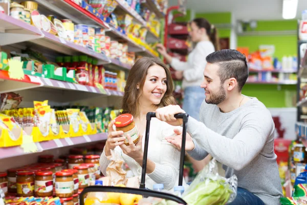 Customers  near shelves with canned goods
