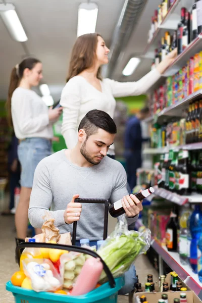 Customers  near shelves with canned goods