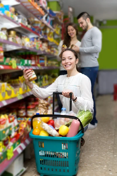Customers  near shelves with canned goods