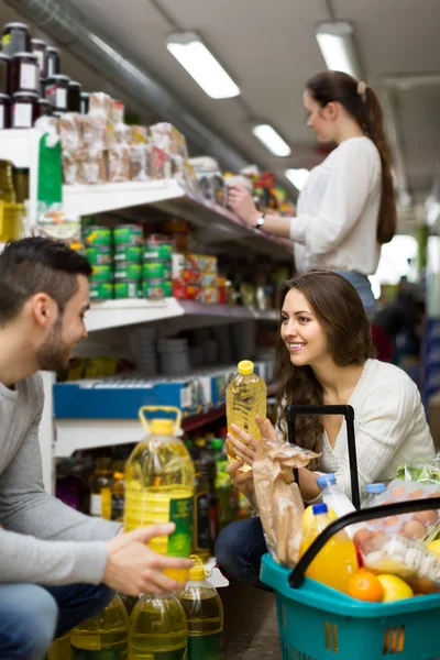 Customers  near shelves with canned goods