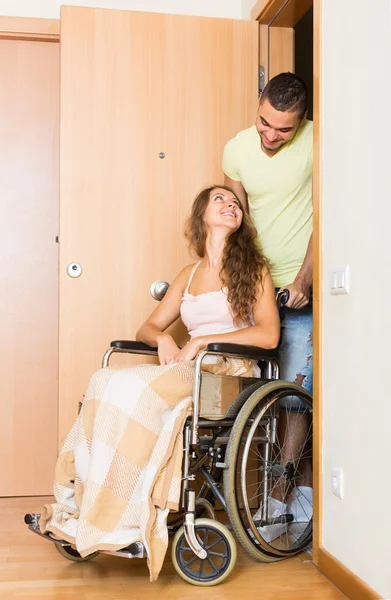 Couple with girl in wheelchair near door