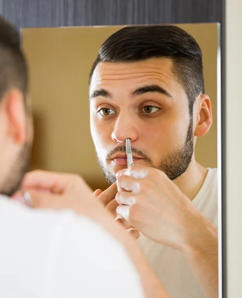 Male remove hair from his nose