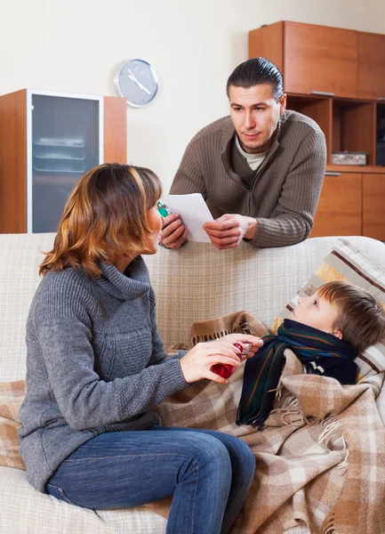 Parents giving syrup to son