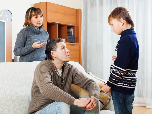 Mother and father scolding son