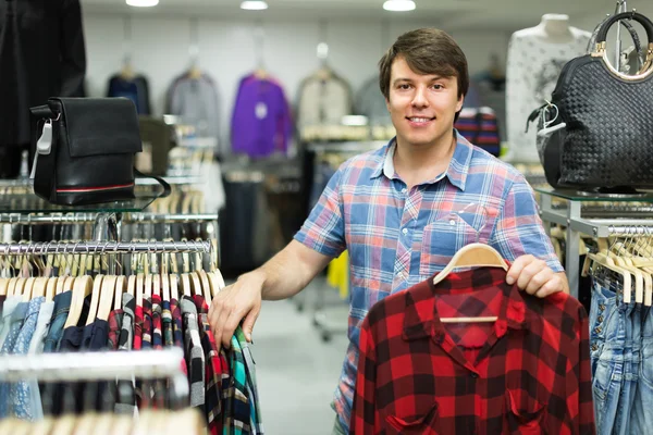 Male choosing shirts in the shop
