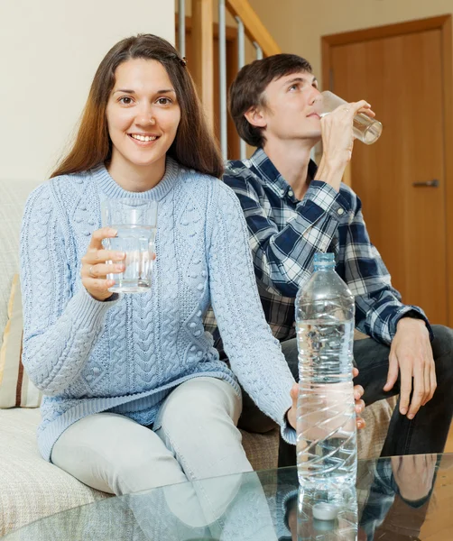 Couple in home drinking water