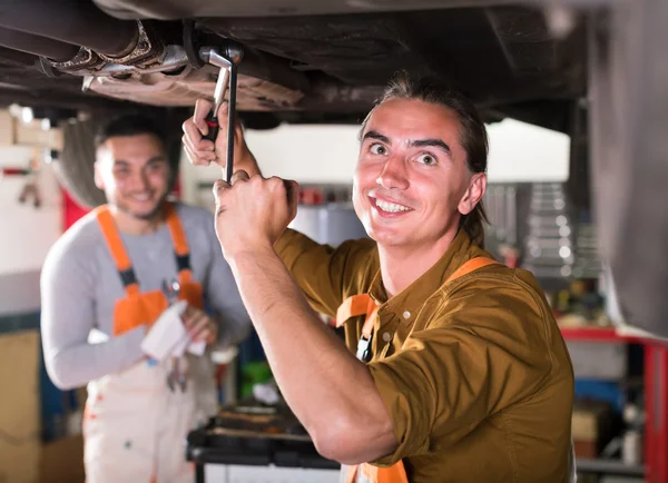 Serviceman repairing exhaust system