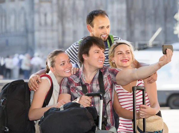 Men and women with luggage doing selfie