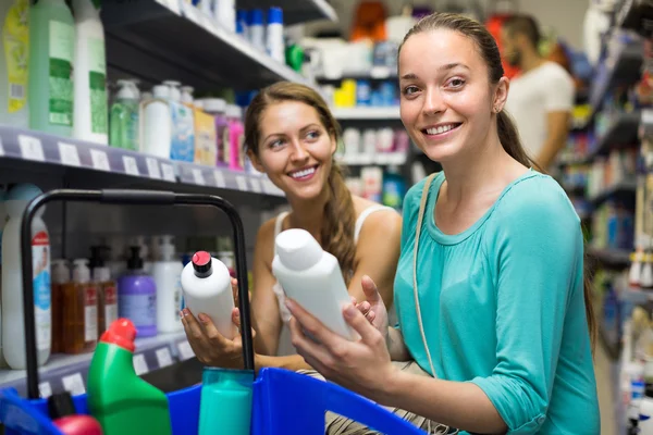 Woman choosing shampoo at store