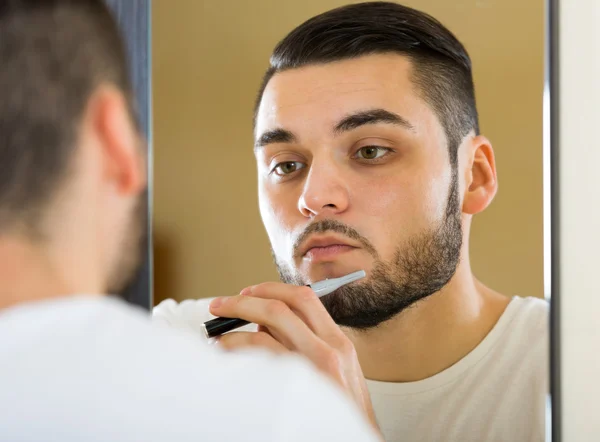 Man Shaving beard with trimmer