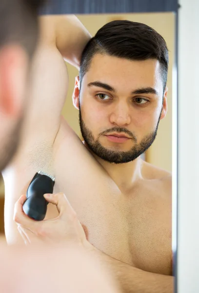 Man shaving armpit