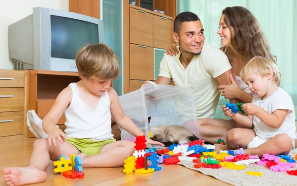 Family of four at home with toys