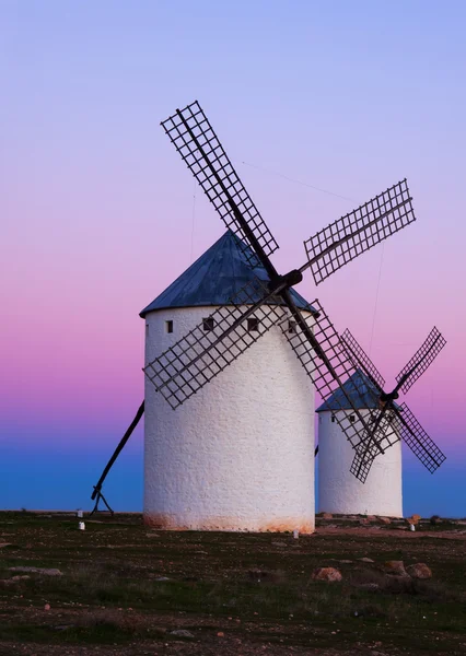 Two windmills at field in evening